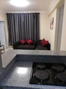 a kitchen counter with a stove top in a living room at Afsaal flats in Amanzimtoti