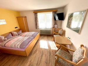 1 dormitorio con 1 cama, mesa y sillas en Hotel Charlott, en Eisenbach
