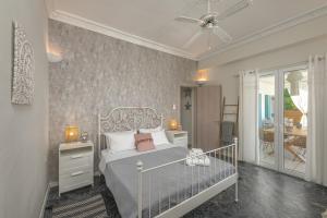 1 Schlafzimmer mit einem weißen Bett und einem Balkon in der Unterkunft Anemos Beach House in Alikanas