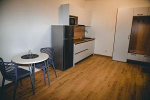 een kleine keuken met een tafel en een koelkast bij Four Rooms Apartments in Tsjerkasi