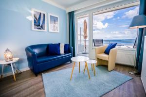 ein Wohnzimmer mit einem blauen Sofa und einem Tisch in der Unterkunft Studio 26 " Segelglück" mit Meerblick in Grömitz