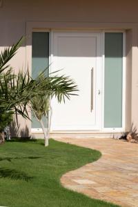 考特索納里的住宿－SAMIRAM，房屋前有棕榈树的白色车库门