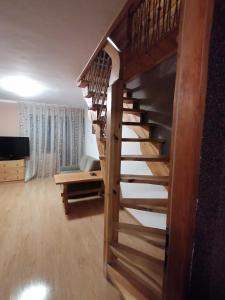 uma escada em espiral de madeira numa sala de estar em Pokoje Gościnne Alexandra em Stronie Śląskie