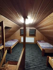 an attic room with two beds and a light at Pokoje Gościnne Alexandra in Stronie Śląskie