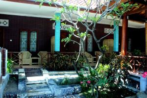 a garden with a cross in front of a building at Krisna Bungalows and Restaurant in Sekotong