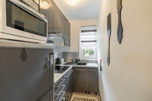 a small kitchen with a sink and a refrigerator at Le Saphir in Branville