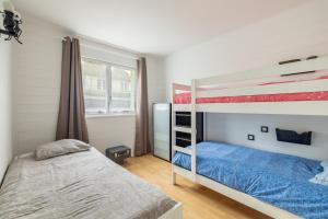 a bedroom with two bunk beds and a blue bed at Le Saphir in Branville +11 photos