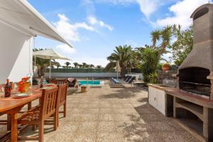 an outdoor patio with a grill and a pool at Lanzarote Villa Irina Marina Rubicón in Playa Blanca