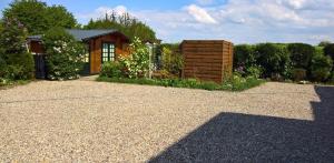 einen Garten mit einem Haus und einer Kieseinfahrt in der Unterkunft Zur Schwedenschanze 2 in Hohen Wieschendorf