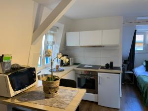 a kitchen with a table with a microwave and a kitchen with a couch at Coquet Studio Colmar Centre in Colmar