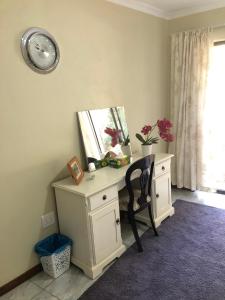 a desk with a mirror and a chair in a room at Cozy One bedroom garden cottage in Roodepoort