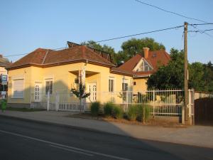 una casa gialla con una recinzione di fronte di Aranyosház-Vendégház a Budapest