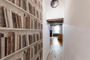 einen Flur mit einer Wand voller Bücher in der Unterkunft Casa Calu' in Neapel