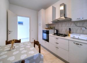 a white kitchen with a table and a sink at Pipe in Metajna