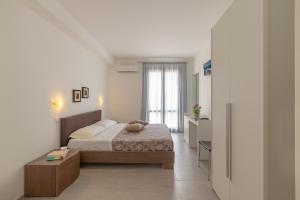 a bedroom with a bed and a room with a window at Hotel Sikania in San Vito lo Capo