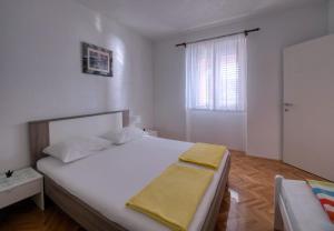 a bedroom with a large white bed and a window at Pipe in Metajna
