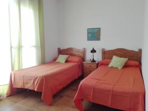 1 dormitorio con 2 camas con sábanas rojas y ventana en Isleta del Moro TERRAZA VISTAS MAR Exclusiva 60 m2 WIFI, en La Isleta del Moro