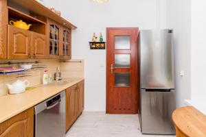 een keuken met een roestvrijstalen koelkast en houten kasten bij Na Lendziona in Gdańsk
