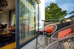 a patio with chairs and a table on a balcony at W&K Apartments - Balance Suite in Koszalin