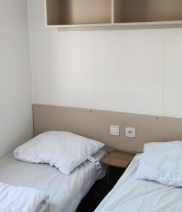 two beds sitting next to each other in a room at Assist' Mobil Home 377 - Mobil Home 3 chambres 6 Personnes in Onzain