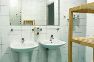 Un baño con dos lavabos y un espejo. en Be Dream Hostel, en Badalona 42 fotos más