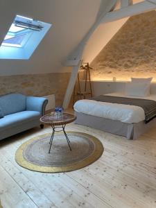 um quarto com uma cama, uma mesa e um sofá em Les Hauts de Grillemont em Cinq-Mars-la-Pile