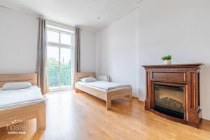 カトヴィツェにあるホステル カトヴィツェ セントラムの暖炉、ベッド、窓が備わる客室です。