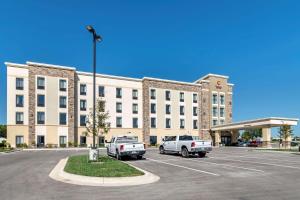 un gran edificio con dos camiones estacionados en un estacionamiento en Comfort Suites Grandview - Kansas City, en Grandview