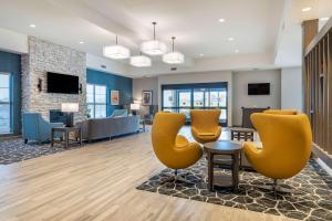 a lobby with yellow chairs and a waiting room at Comfort Suites Grandview - Kansas City in Grandview