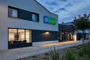 a building with a sign on the side of it at Sure Hotel by Best Western Les Portes de Montauban in Montauban