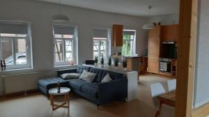 a living room with a blue couch and some windows at Ferienwohnung Alte Dorfschule in Witzenhausen