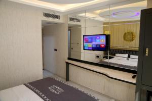 Cette chambre dispose d'une télévision, d'un lit et d'un miroir. dans l'établissement The Grand Tower Hotel, à Istanbul