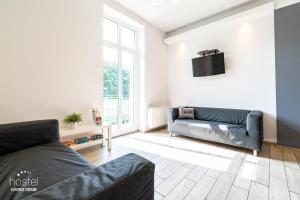 sala de estar con sofá y TV en la pared en Hostel Katowice Centrum en Katowice