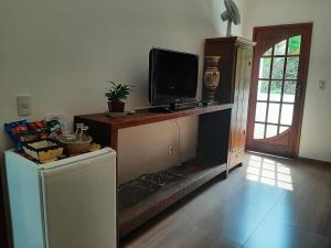uma sala de estar com televisão e lareira em Pousada Mina do capote em Tiradentes