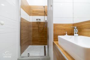 カトヴィツェにあるホステル カトヴィツェ セントラムのバスルーム(シャワー、白いシンク付)