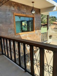 a balcony with a black railing and a window at Pousada Mina do capote in Tiradentes