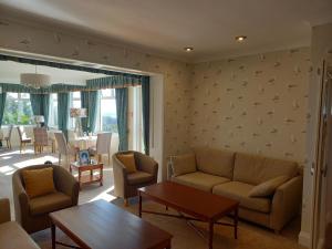ein Wohnzimmer mit einem Sofa, Stühlen und einem Tisch in der Unterkunft Trelawne Hotel in Falmouth