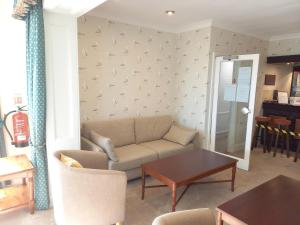 uma sala de estar com um sofá e uma mesa em Trelawne Hotel em Falmouth