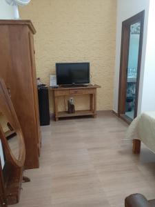 uma sala de estar com televisão numa mesa em Pousada Mina do capote em Tiradentes