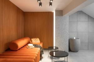 a room with an orange couch and a table at 11 Enteka Acropolis Suites in Athens