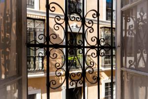 a black wrought iron gate in front of a building at Pájaro Rebelde in Seville