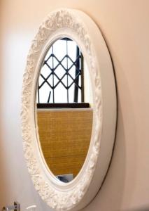 a white mirror on a wall with a window at Precious Paradise Villa in Amanzimtoti