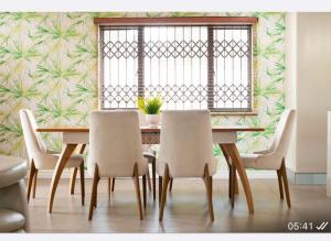 a dining room with a table and chairs and a window at Precious Paradise Villa in Amanzimtoti
