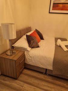 a bedroom with two beds and a lamp on a night stand at The Symphony Apartment in Liverpool