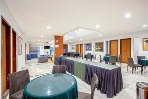 a dining room with tables and chairs and a bar at Sans Hotel Prime Cailendra Yogyakarta by RedDoorz in Yogyakarta