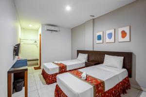 Postel nebo postele na pokoji v ubytování Sans Hotel Prime Cailendra Yogyakarta by RedDoorz