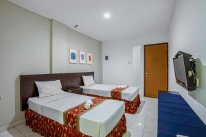 Postel nebo postele na pokoji v ubytování Sans Hotel Prime Cailendra Yogyakarta by RedDoorz