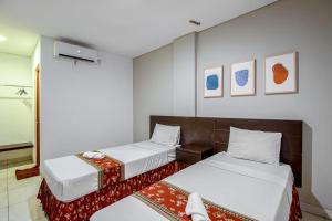 Postel nebo postele na pokoji v ubytování Sans Hotel Prime Cailendra Yogyakarta by RedDoorz