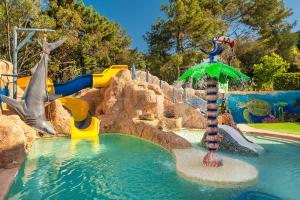 a water park with a water slide and an umbrella at Apartaments Els Llorers in Lloret de Mar