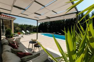 a patio with a white pergola next to a pool at Villa Marta Luxury House with Heated Pool in Plano +45 photos
